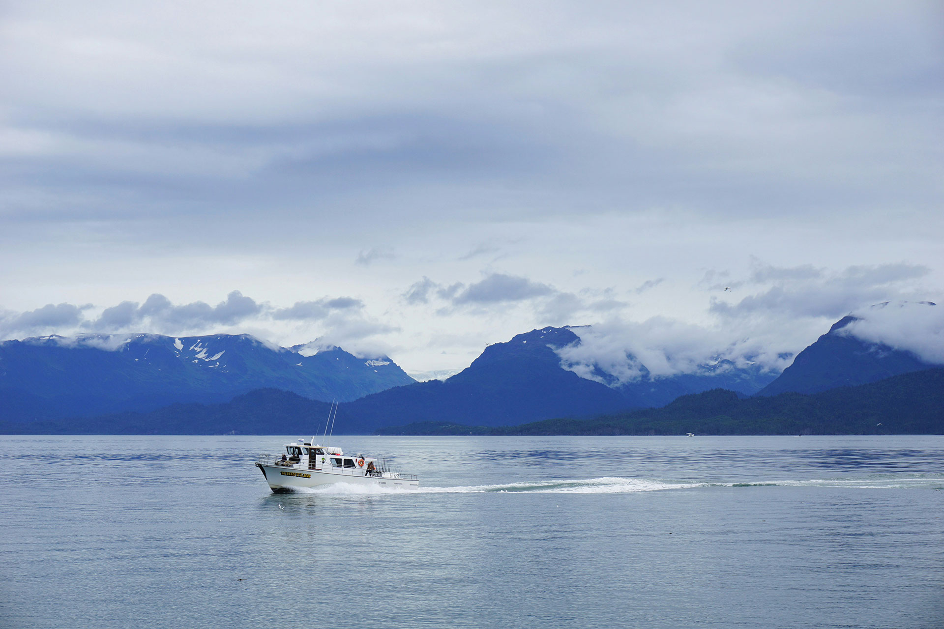 Alaskan fishing boat with mountain range in background